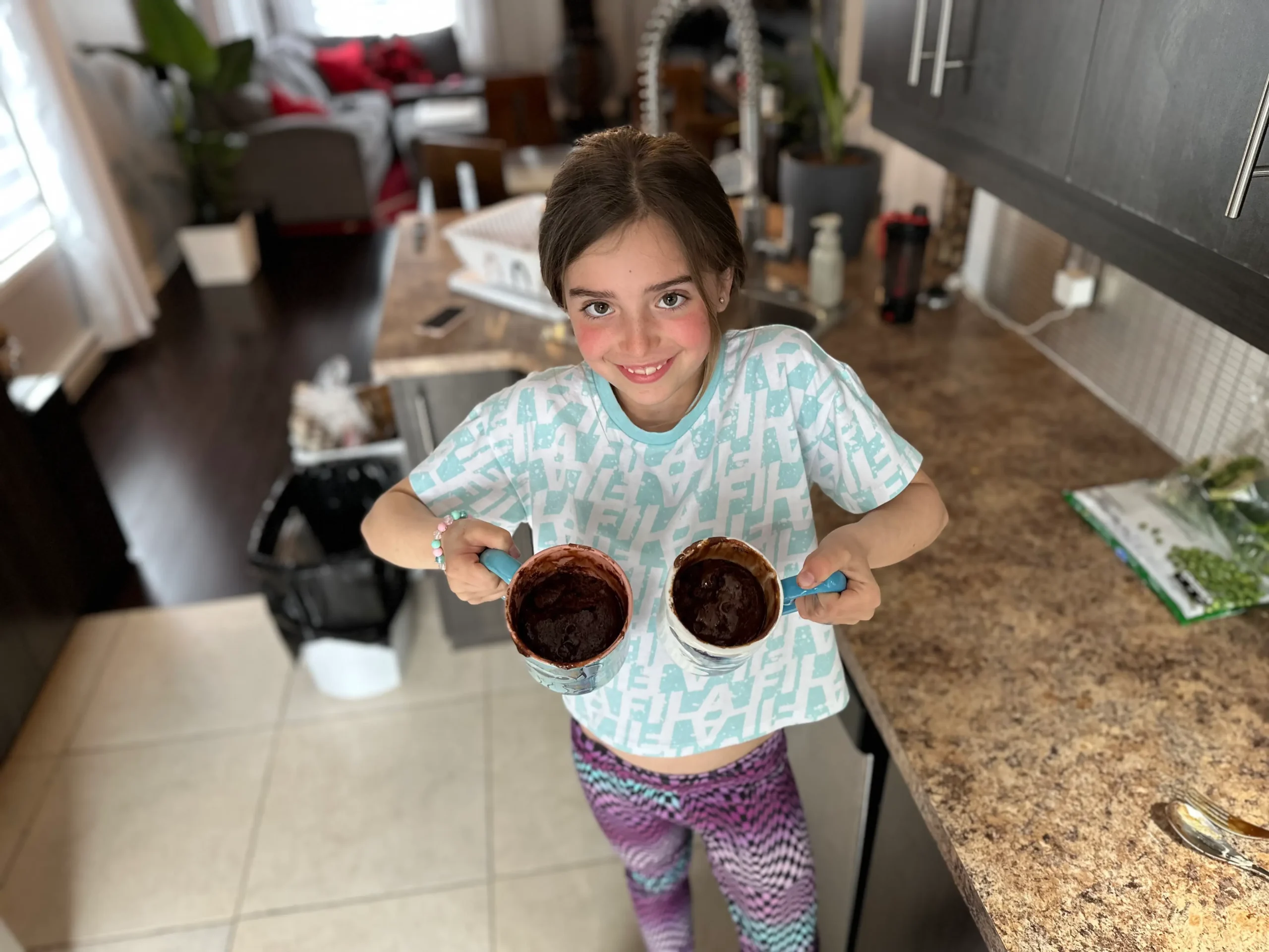 Enfant présentant fièrement deux Mug Cakes au chocolat